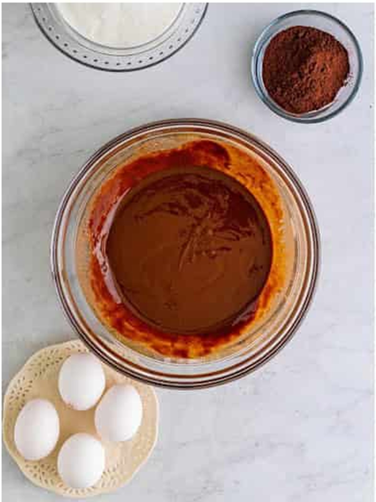Melted butter and chocolate chips whisked smooth in a glass bowl for brownie batter.