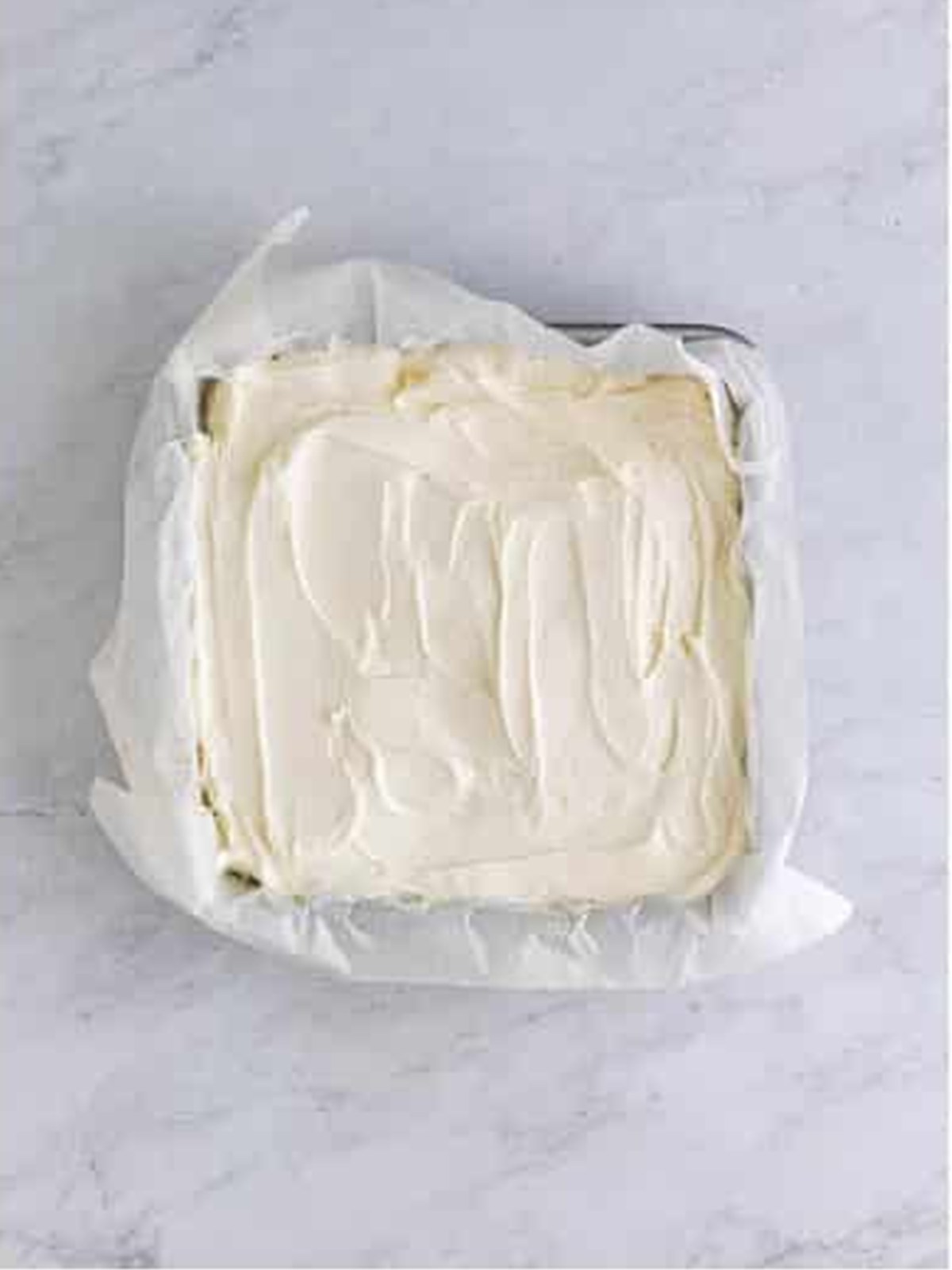 Softened vanilla ice cream spread over a brownie layer in the pan.