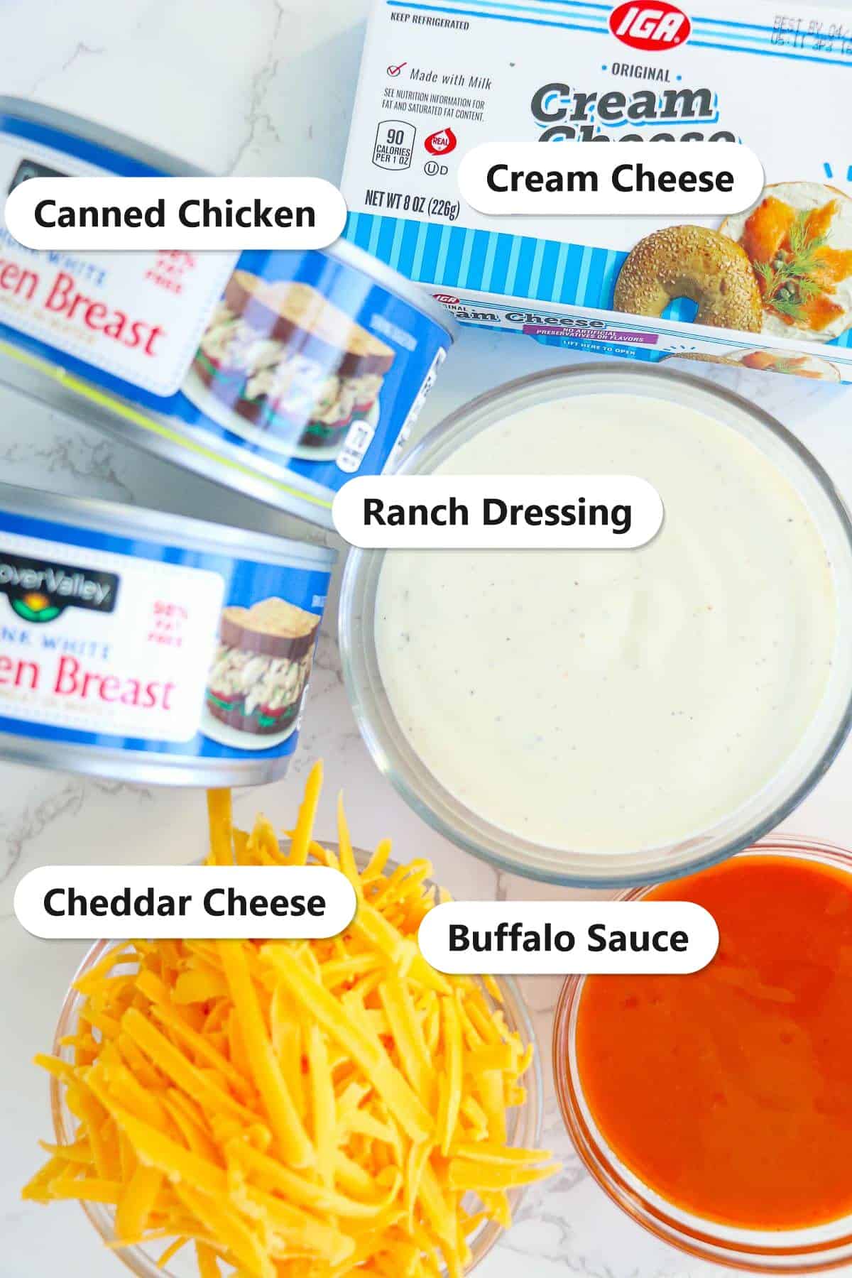 Labeled ingredients for buffalo chicken egg rolls including canned chicken, cream cheese, ranch dressing, cheddar cheese, and buffalo sauce.