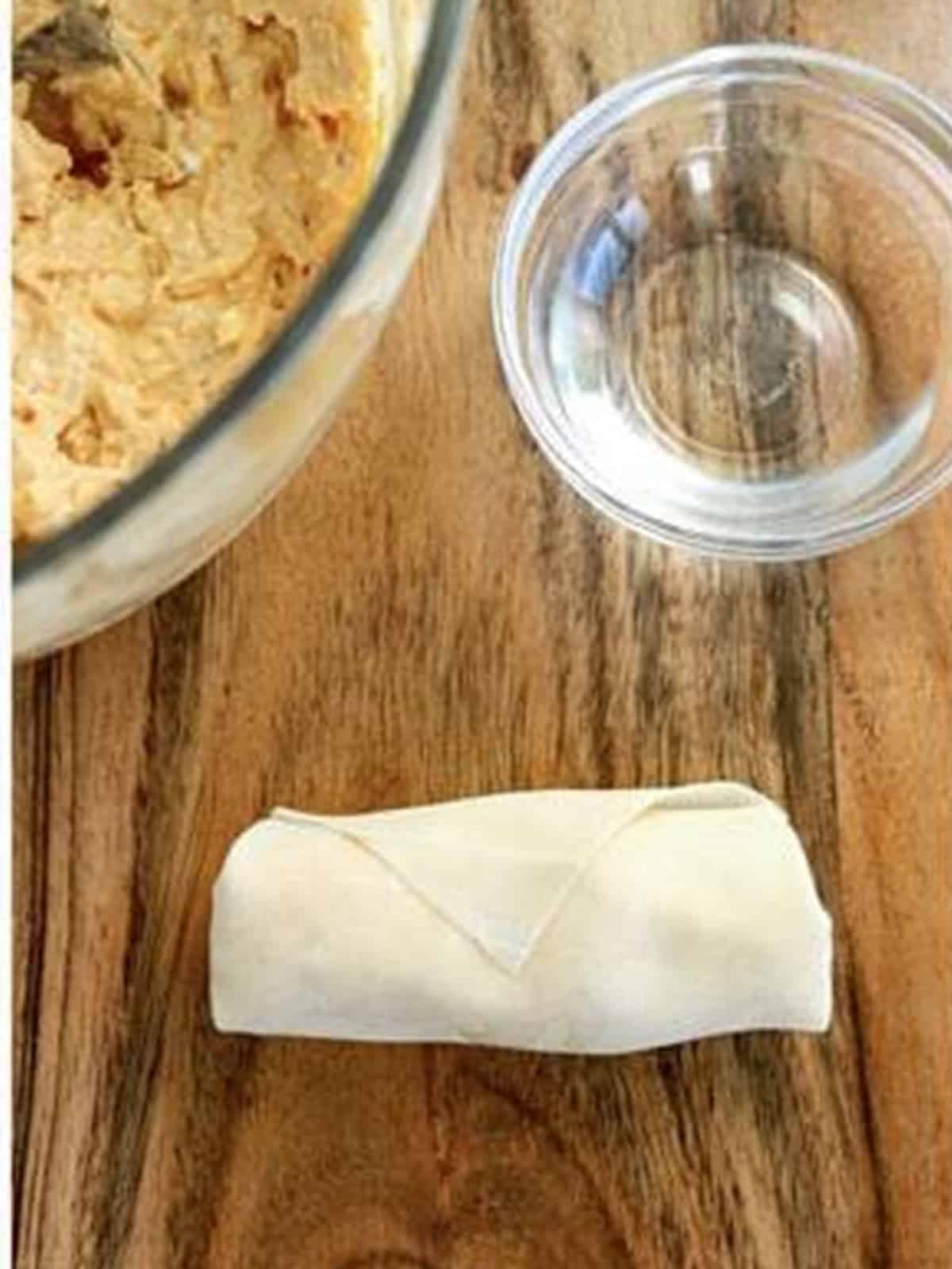 A rolled and sealed buffalo chicken egg roll.
