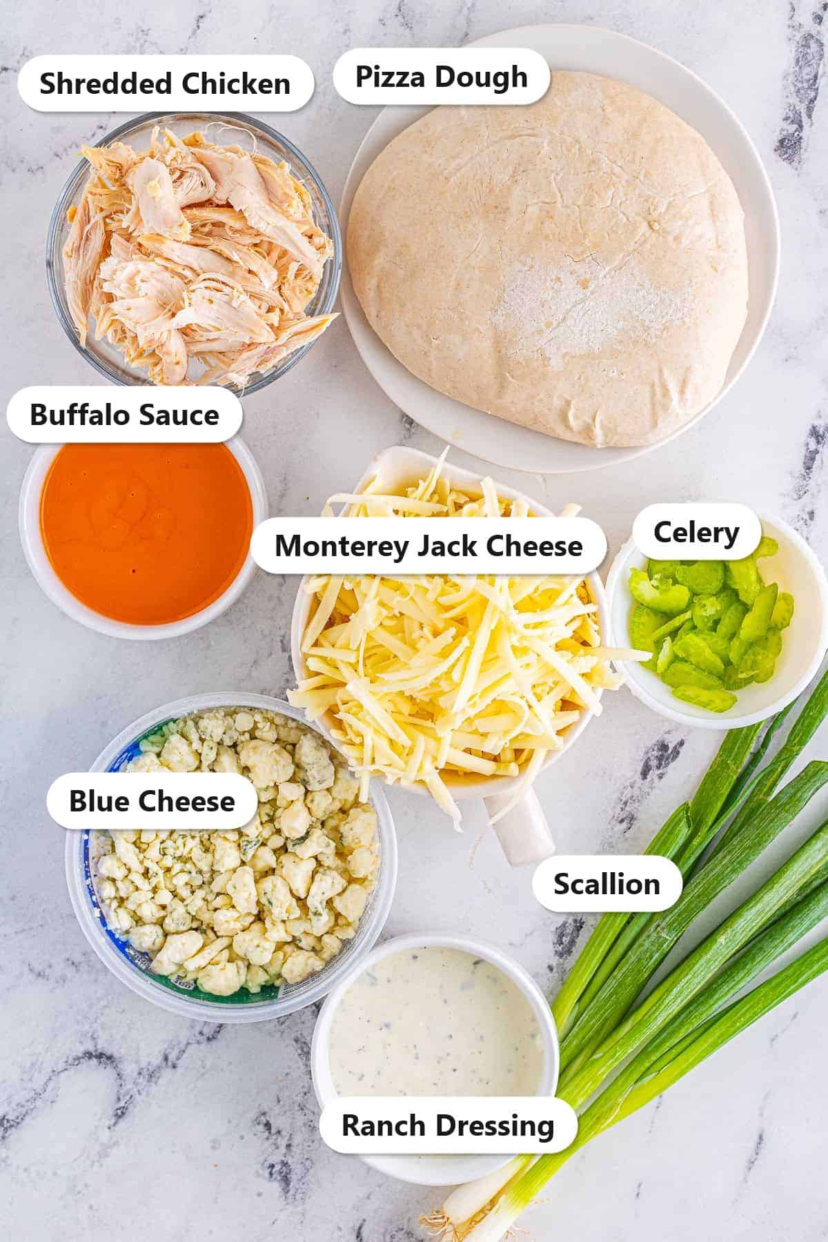 Labeled ingredients for buffalo chicken pizza including dough, shredded chicken, buffalo sauce, ranch, cheeses, celery, and scallion.