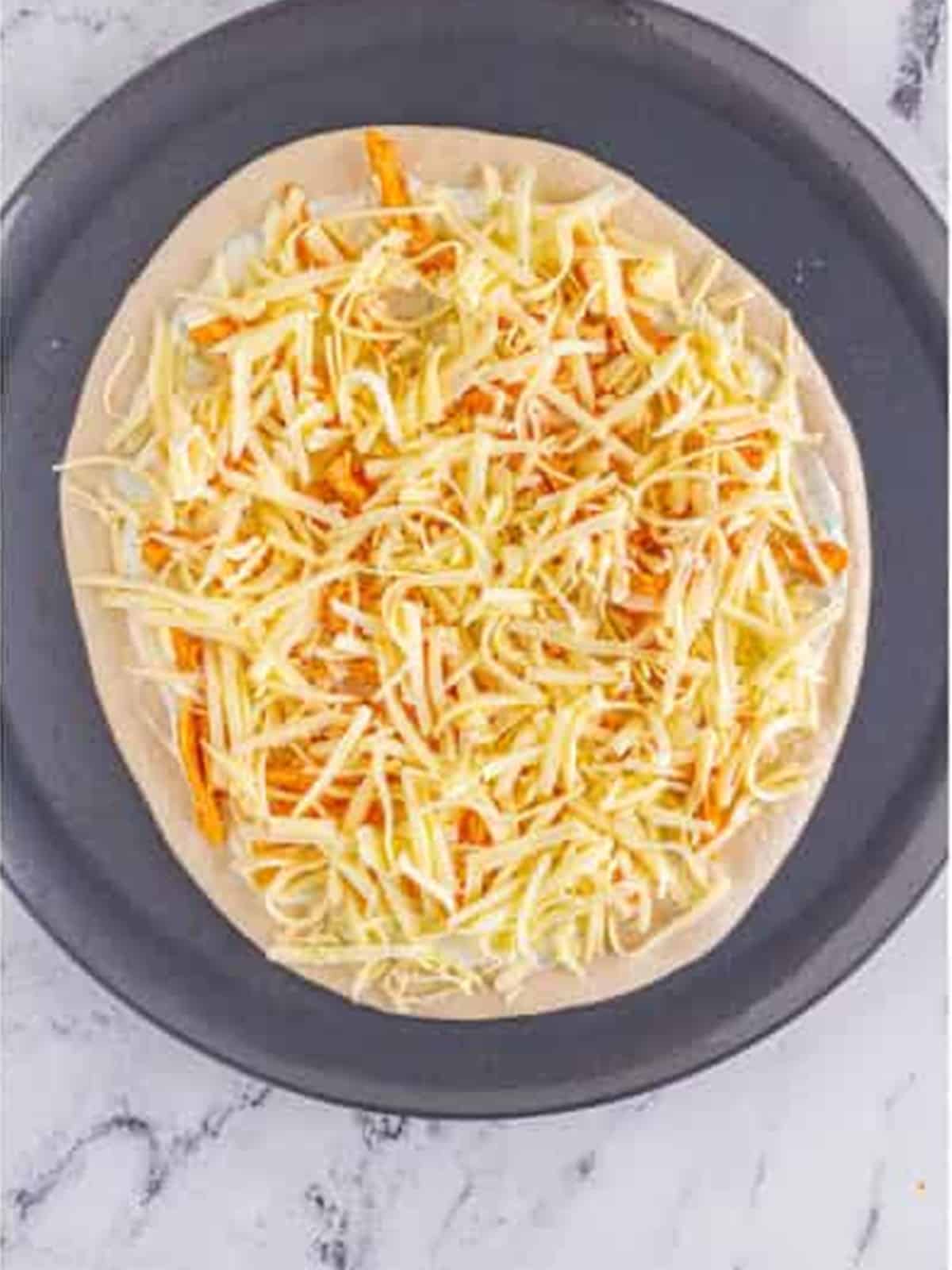 Baked buffalo chicken pizza topped with ranch, blue cheese, celery, and scallions.