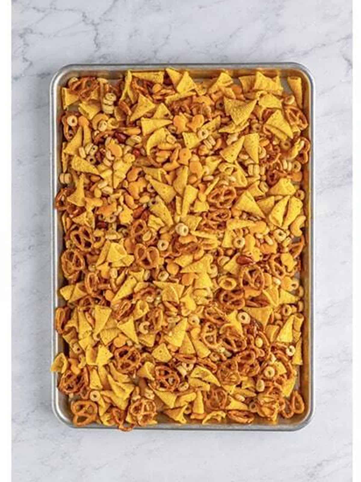 Ranch snack mix spread in an even layer on a sheet tray.