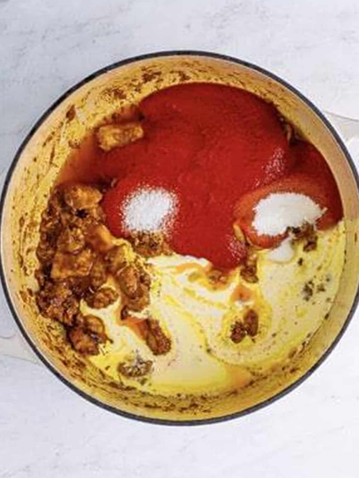 Tomato passata, cream, sugar, and salt added to the cooked chicken for butter chicken sauce.