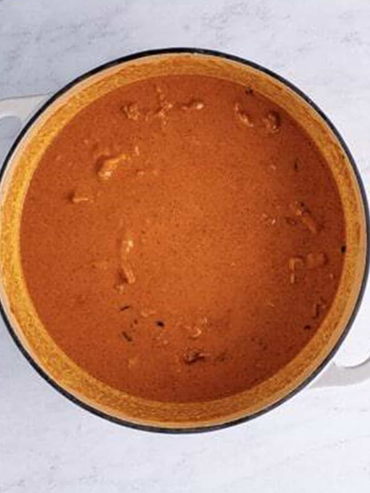 Finished creamy butter chicken simmered into a rich orange sauce.