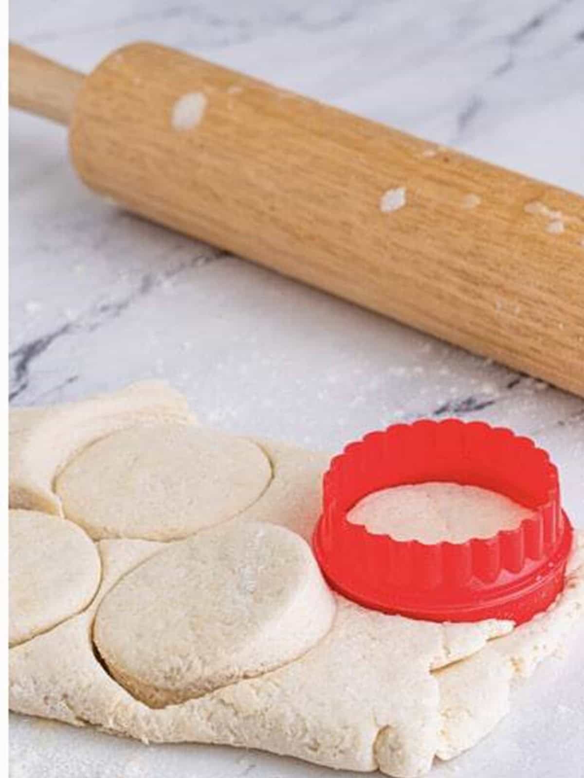 Cutting out buttermilk biscuits with a round biscuit cutter.