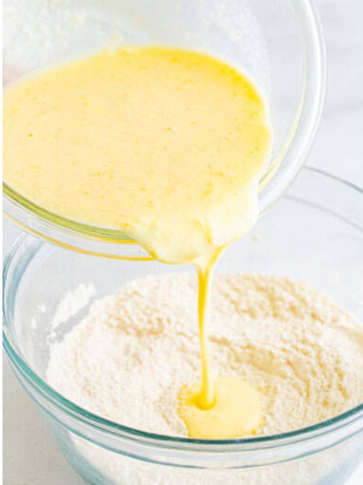 Pouring the wet ingredients into the dry for Buttermilk Pancakes batter.