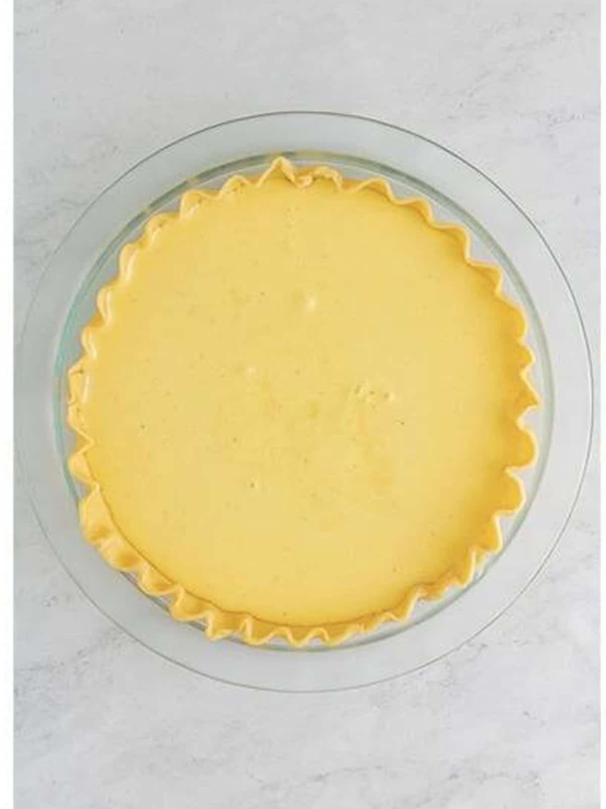 Buttermilk Pie filling poured into a pie crust.