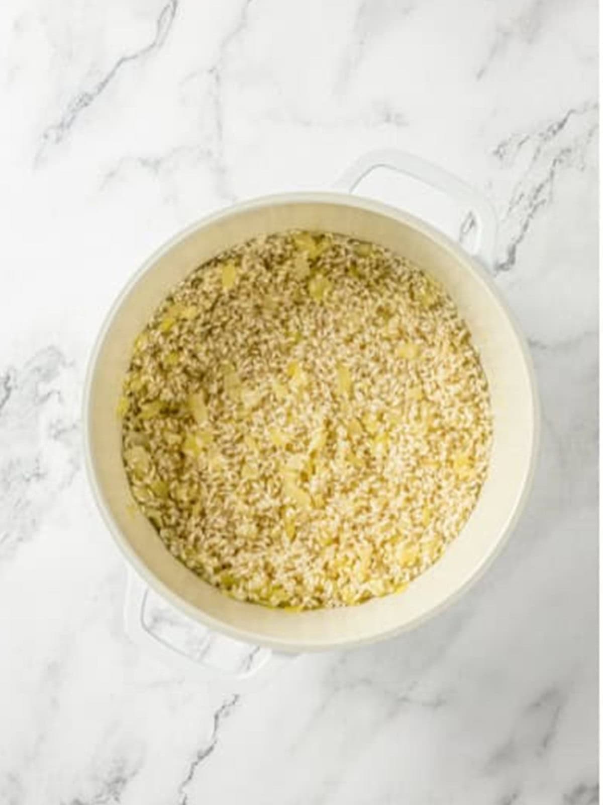 Arborio rice toasting in the pot with onion and garlic.
