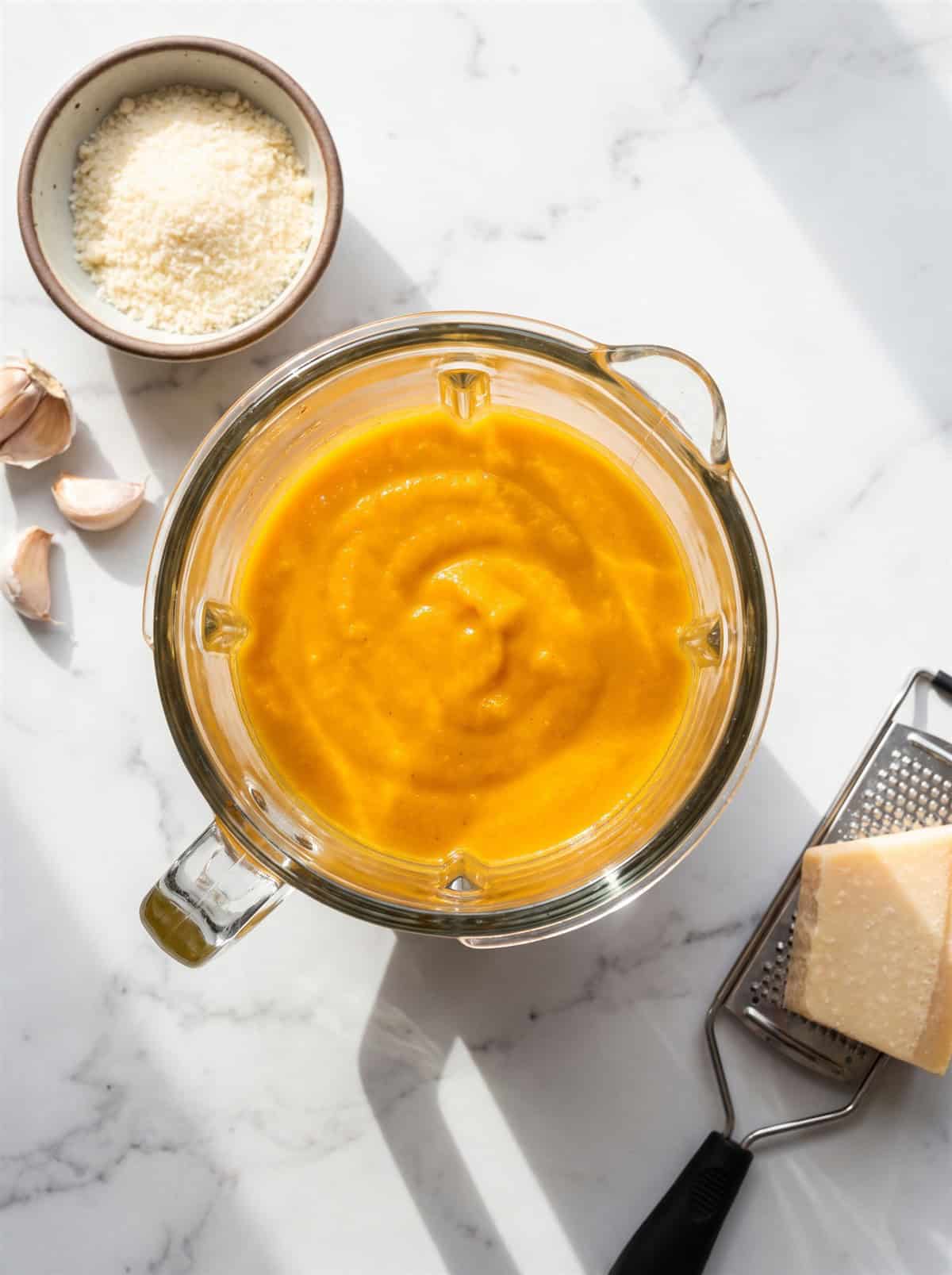 Creamy butternut squash sauce blended smooth in a glass jar.