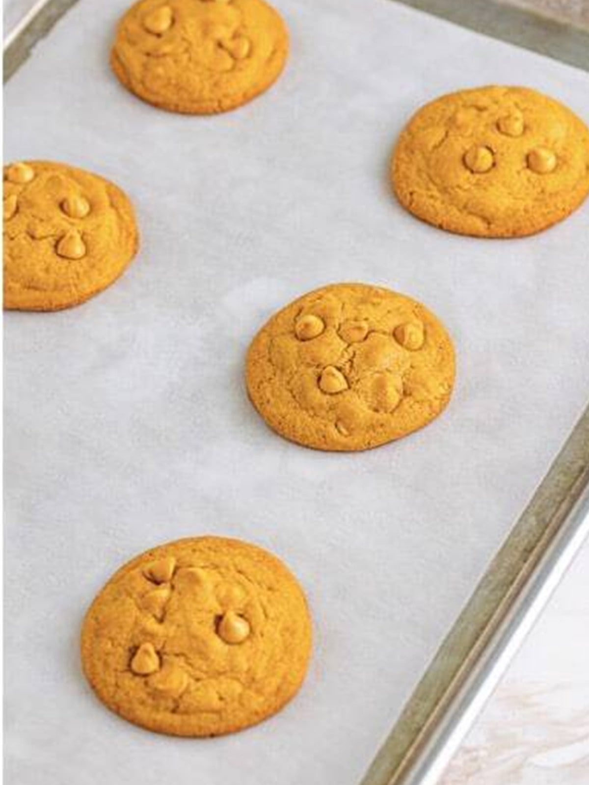 Baked butterscotch cookies on a baking sheet, golden on top.