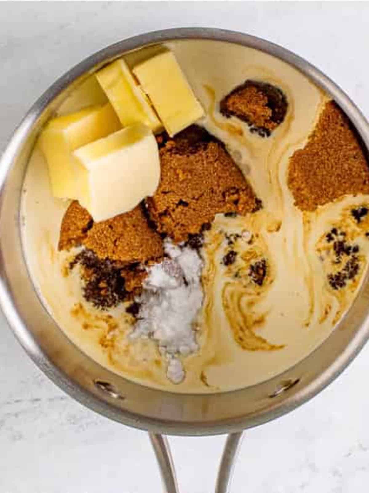 Brown sugar, heavy cream, butter, and corn syrup added to a saucepan to make butterscotch sauce.