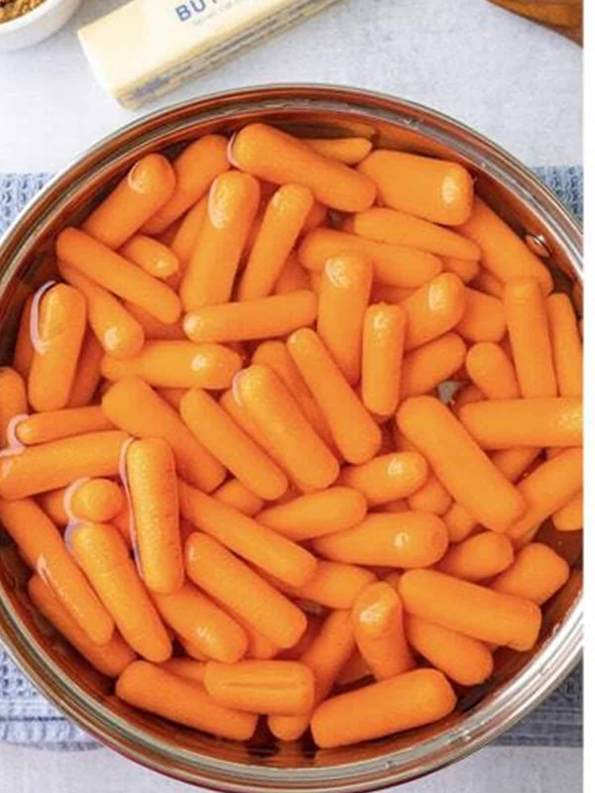 Baby carrots in a pot of salted water before boiling.