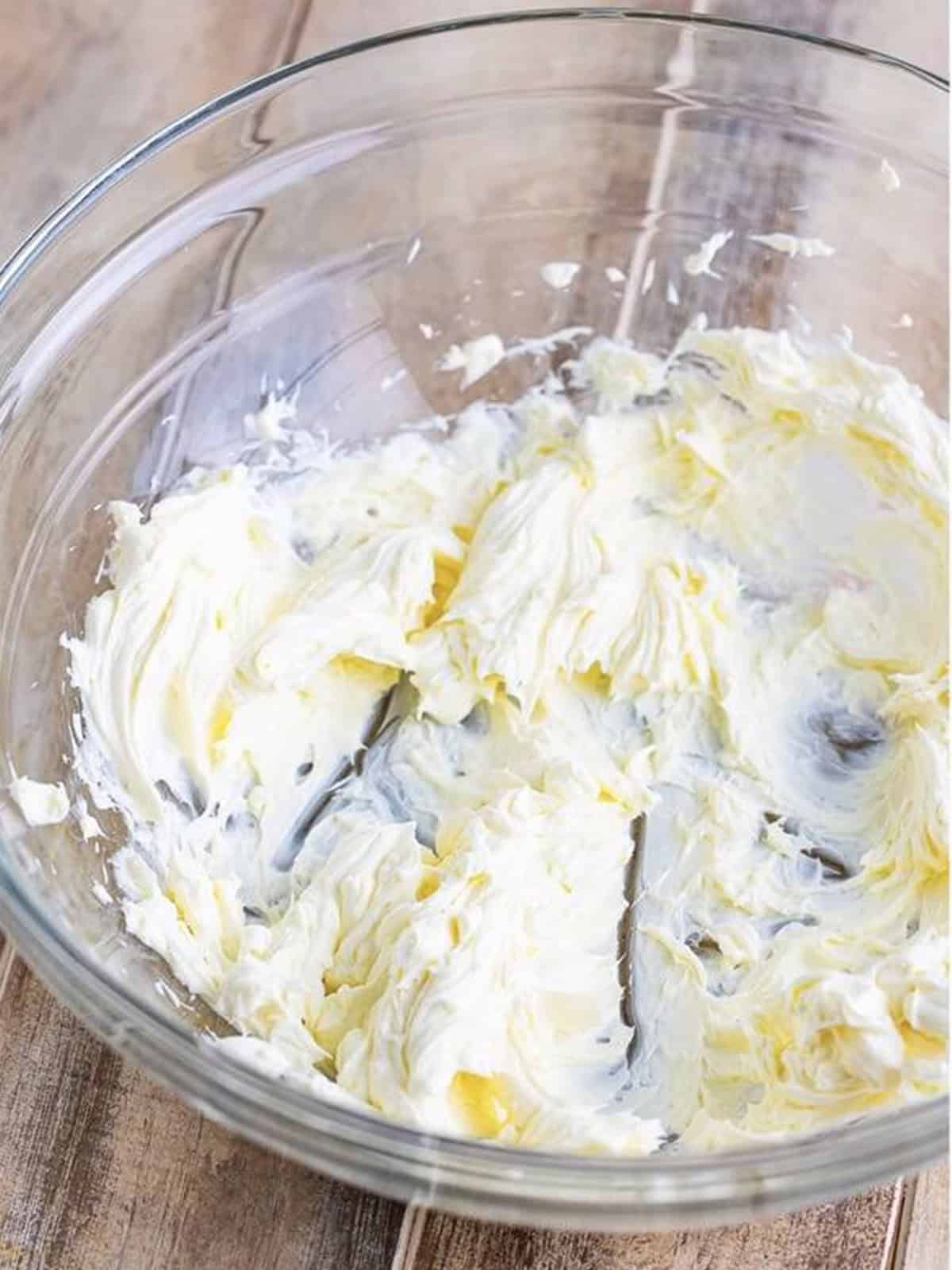 Whipping cream cheese until smooth in a glass bowl.