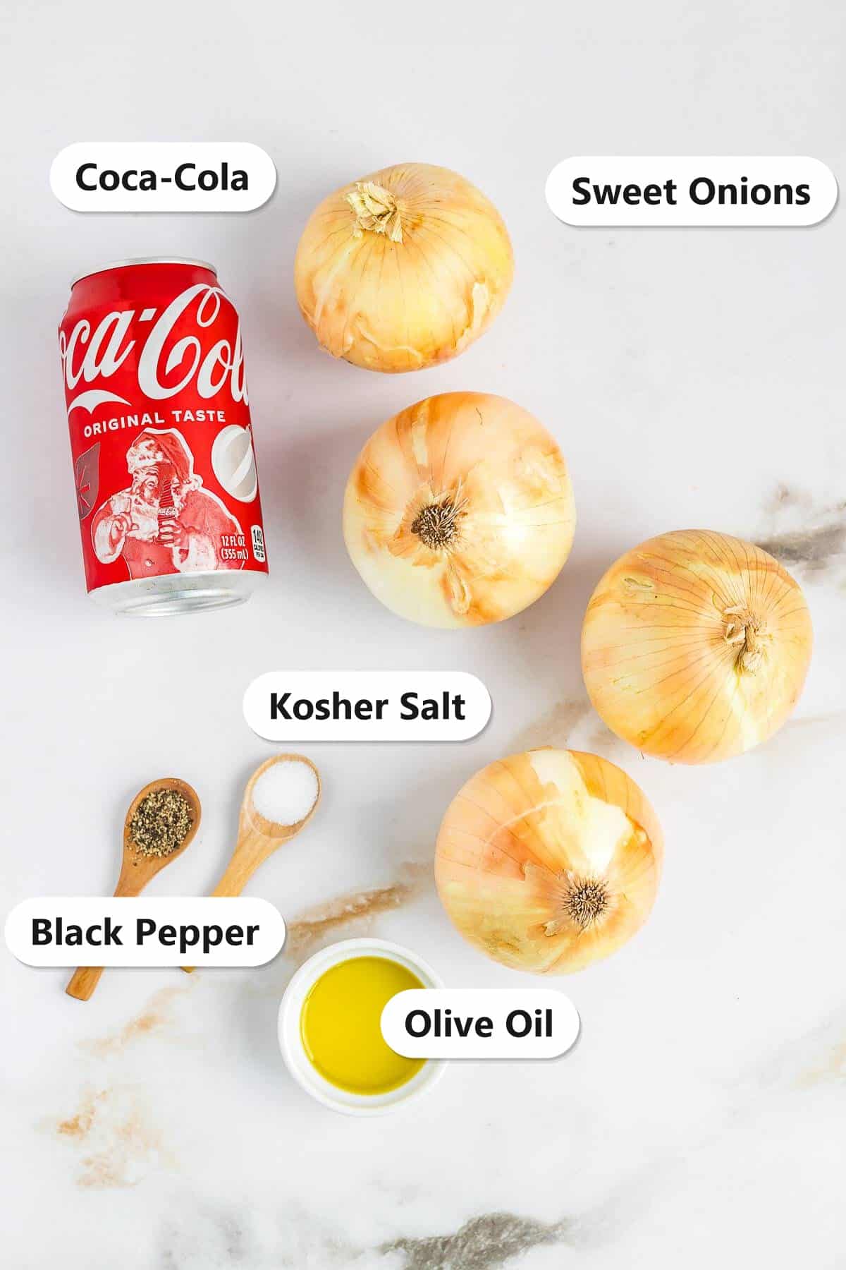 Coca-Cola, sweet onions, kosher salt, black pepper, and olive oil labeled on a marble counter for Caramelized Onions.