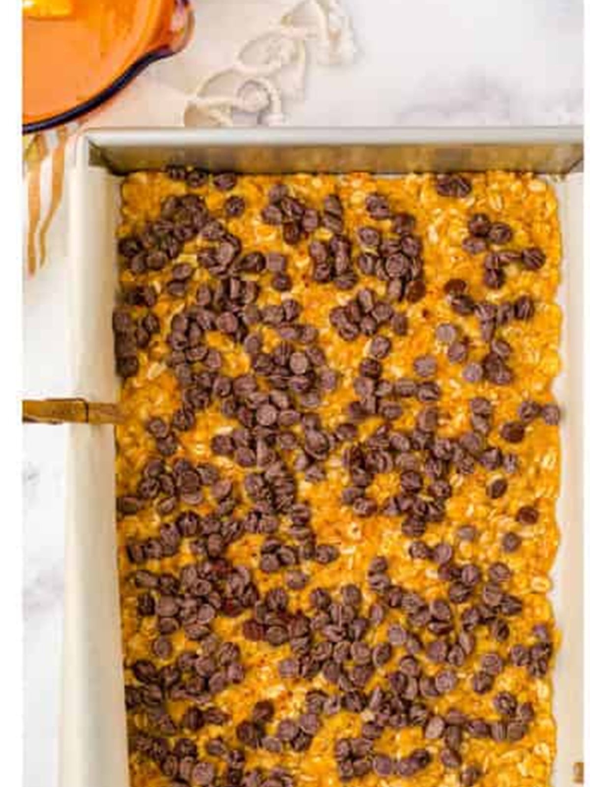 Semi sweet chocolate chips sprinkled over the par baked Carmelitas crust.