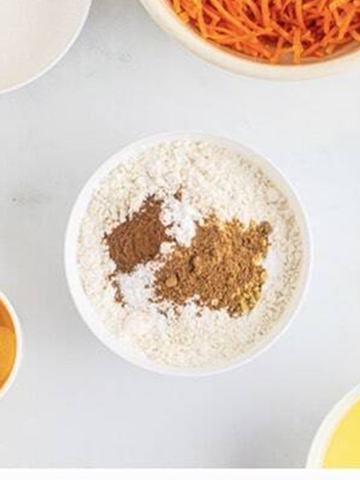 Cake flour and warm spices whisked together in a bowl for carrot bundt cake.