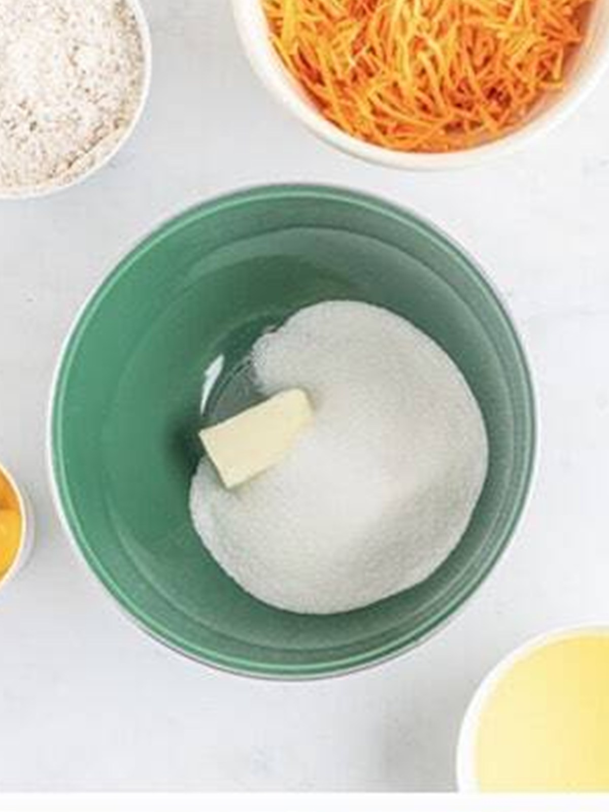 Butter and sugar creamed together in a green mixing bowl.