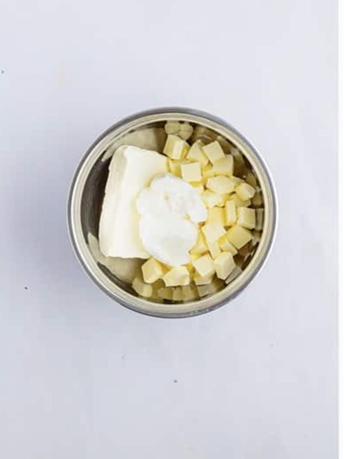 Butter and cream cheese being creamed in a mixing bowl for chocolate chip bundt cake.