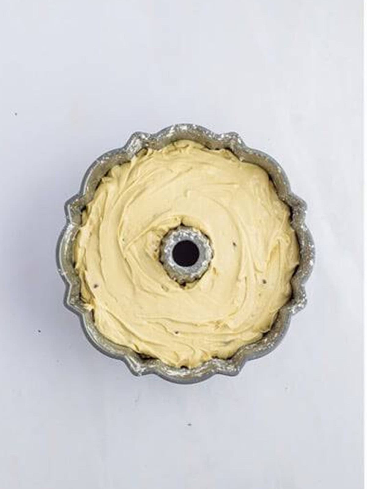 Chocolate chip bundt cake batter poured into a greased bundt pan.