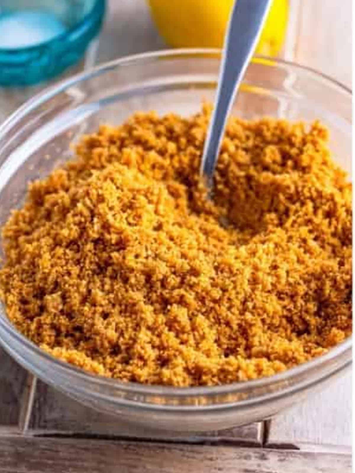 Graham cracker crumbs, butter, and sugar stirred together for the cottage cheese cake crust.