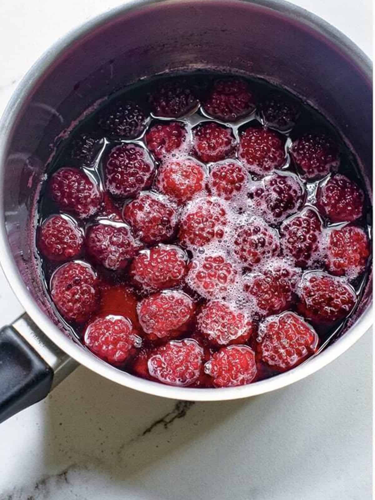 Fresh blackberries, water, lemon juice, and sugar combined in a saucepan.