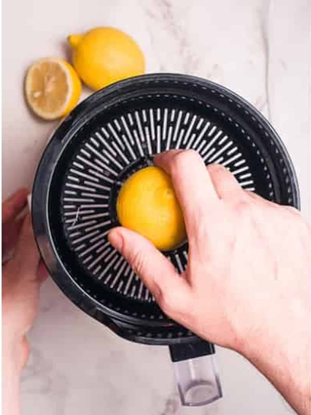 Juicing a lemon on a press for a Peach Arnold Palmer.