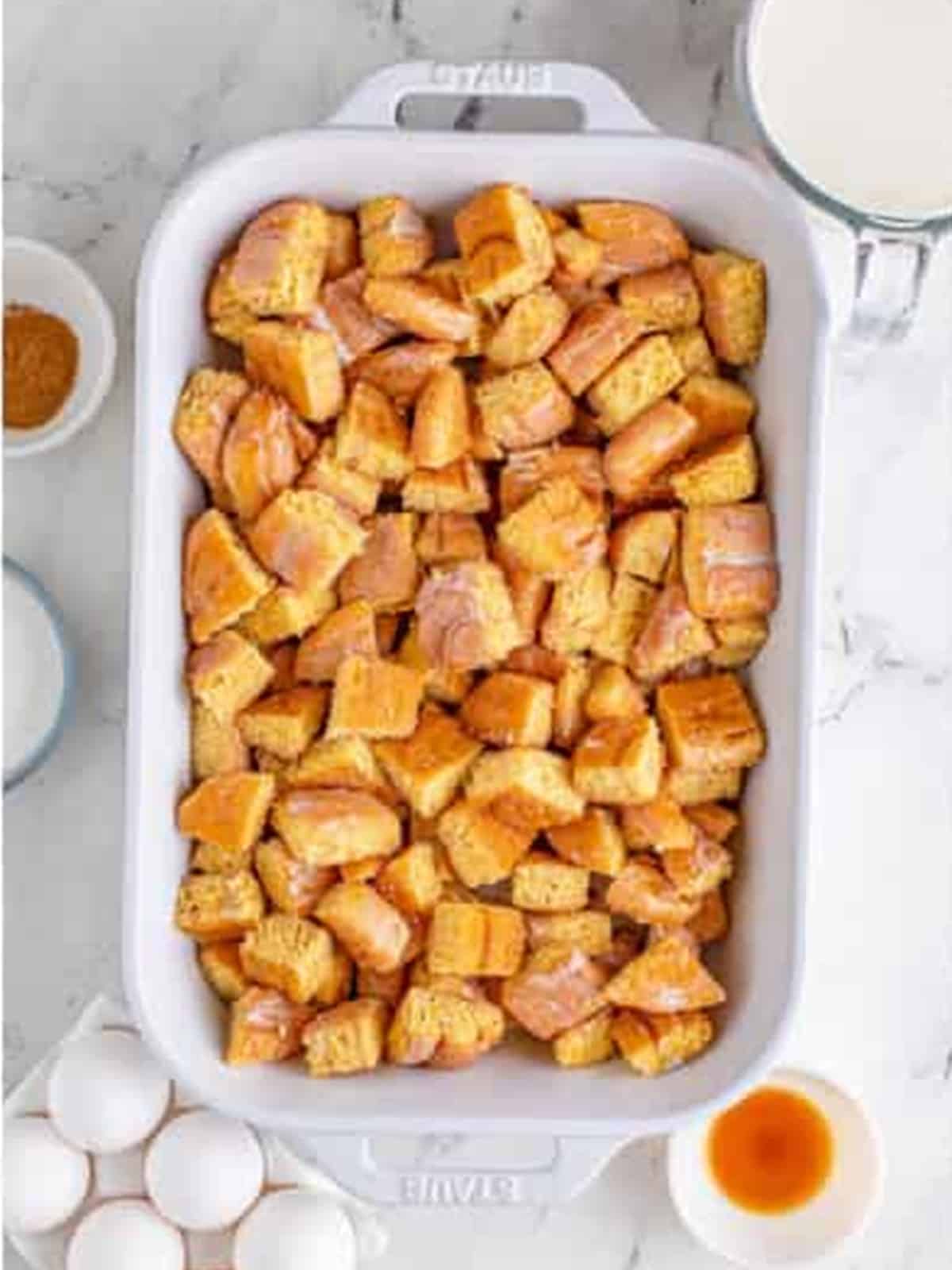 Diced honey buns in a greased baking dish.