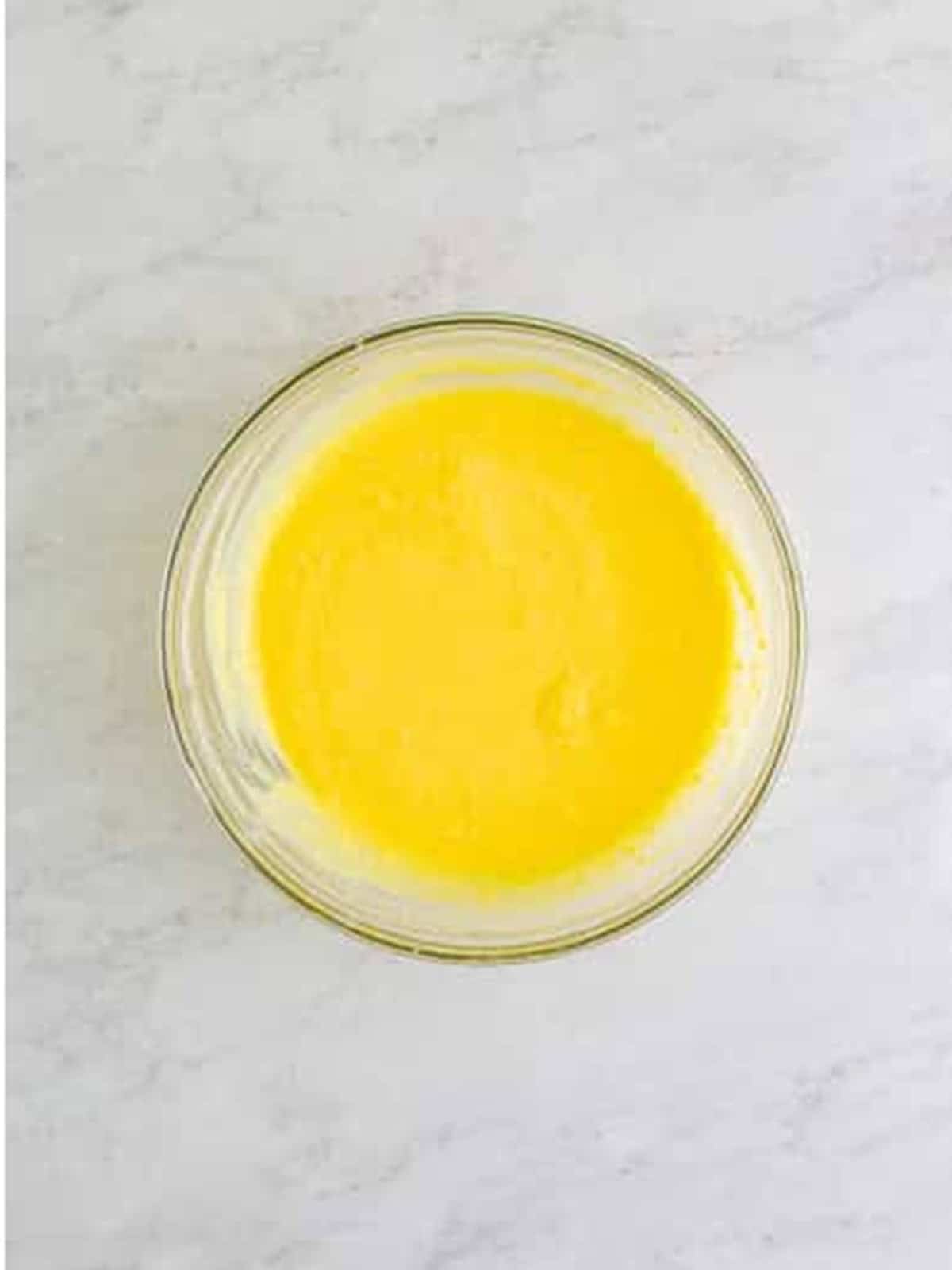 Coconut pudding whisked with milk in a glass bowl.