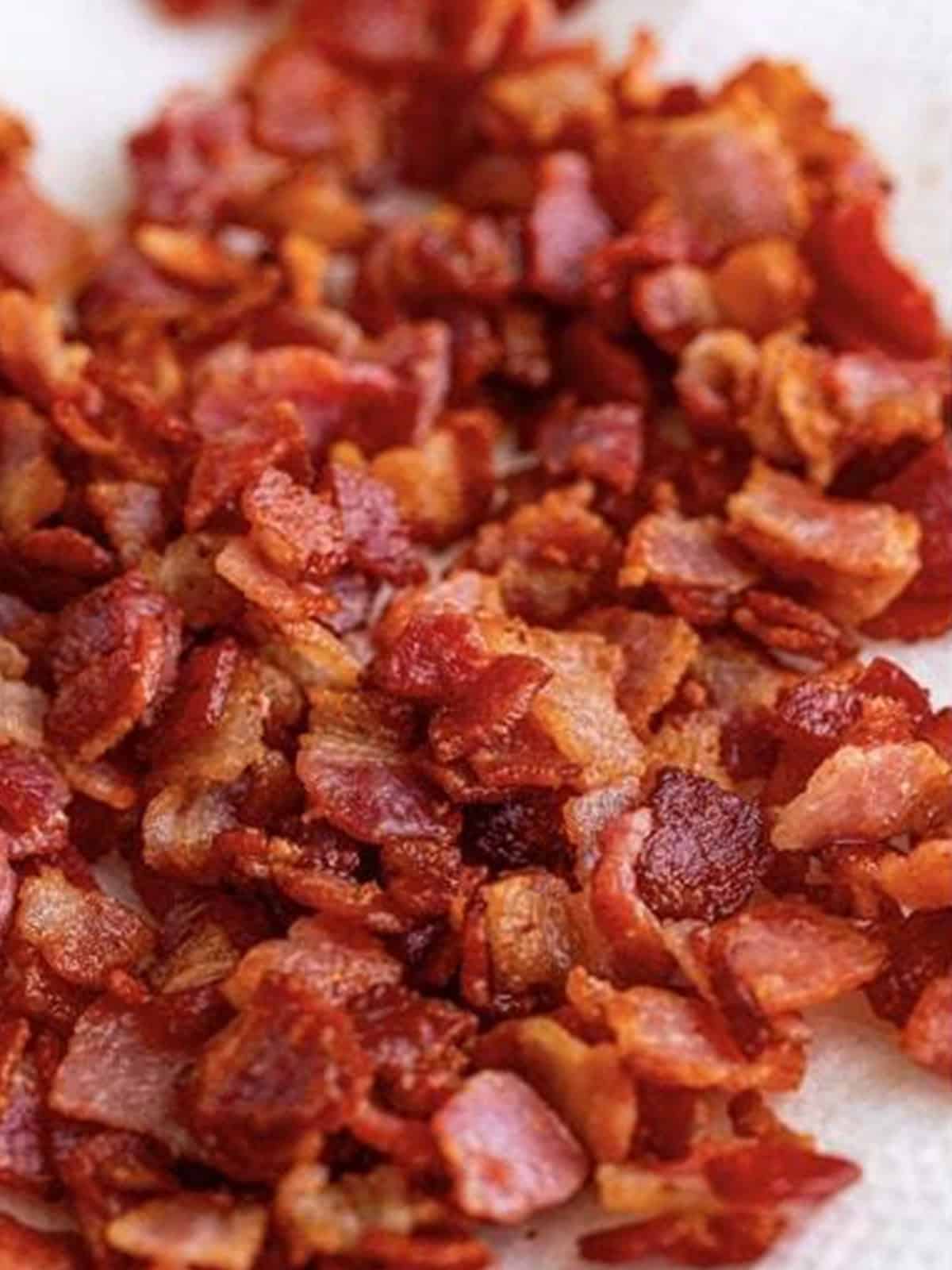 Cooking chopped bacon until crispy in a skillet.