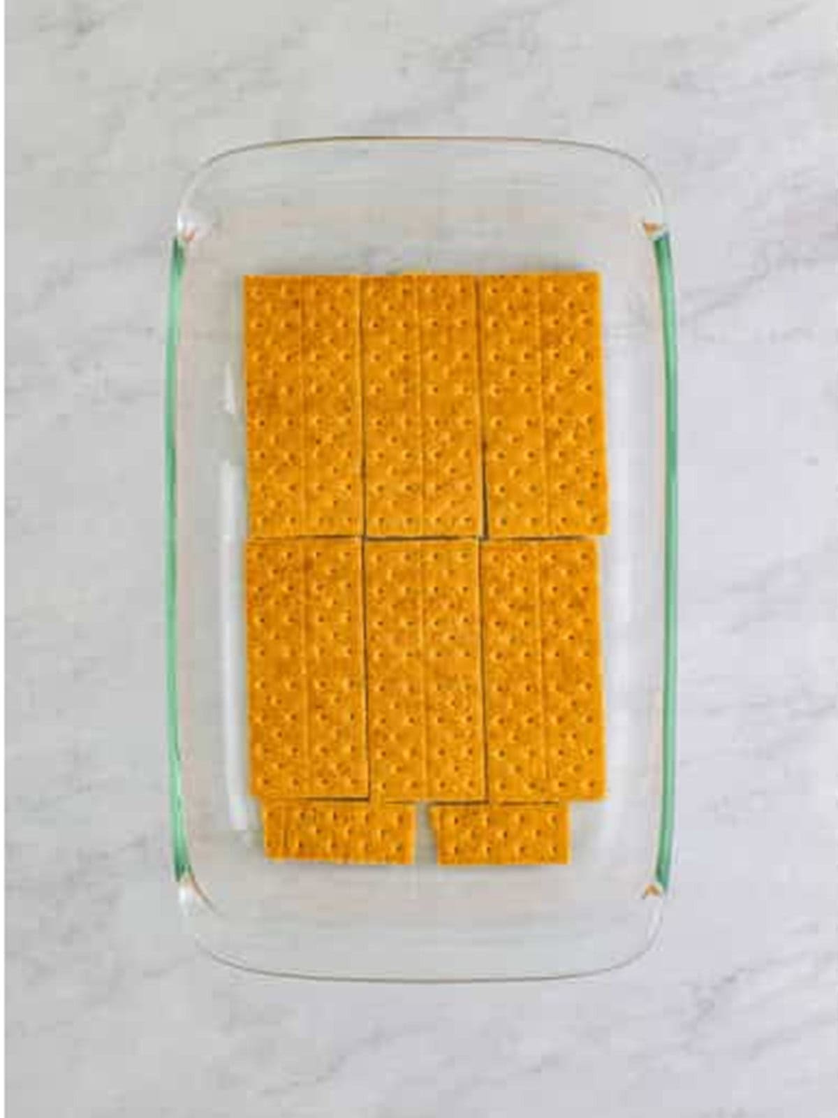 A layer of graham crackers in the bottom of a baking dish.
