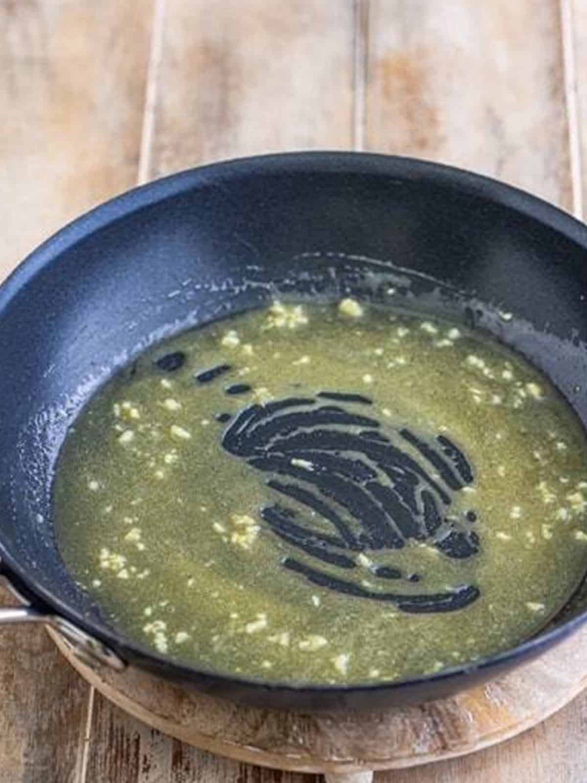 Honey dijon glaze whisked together in a skillet.