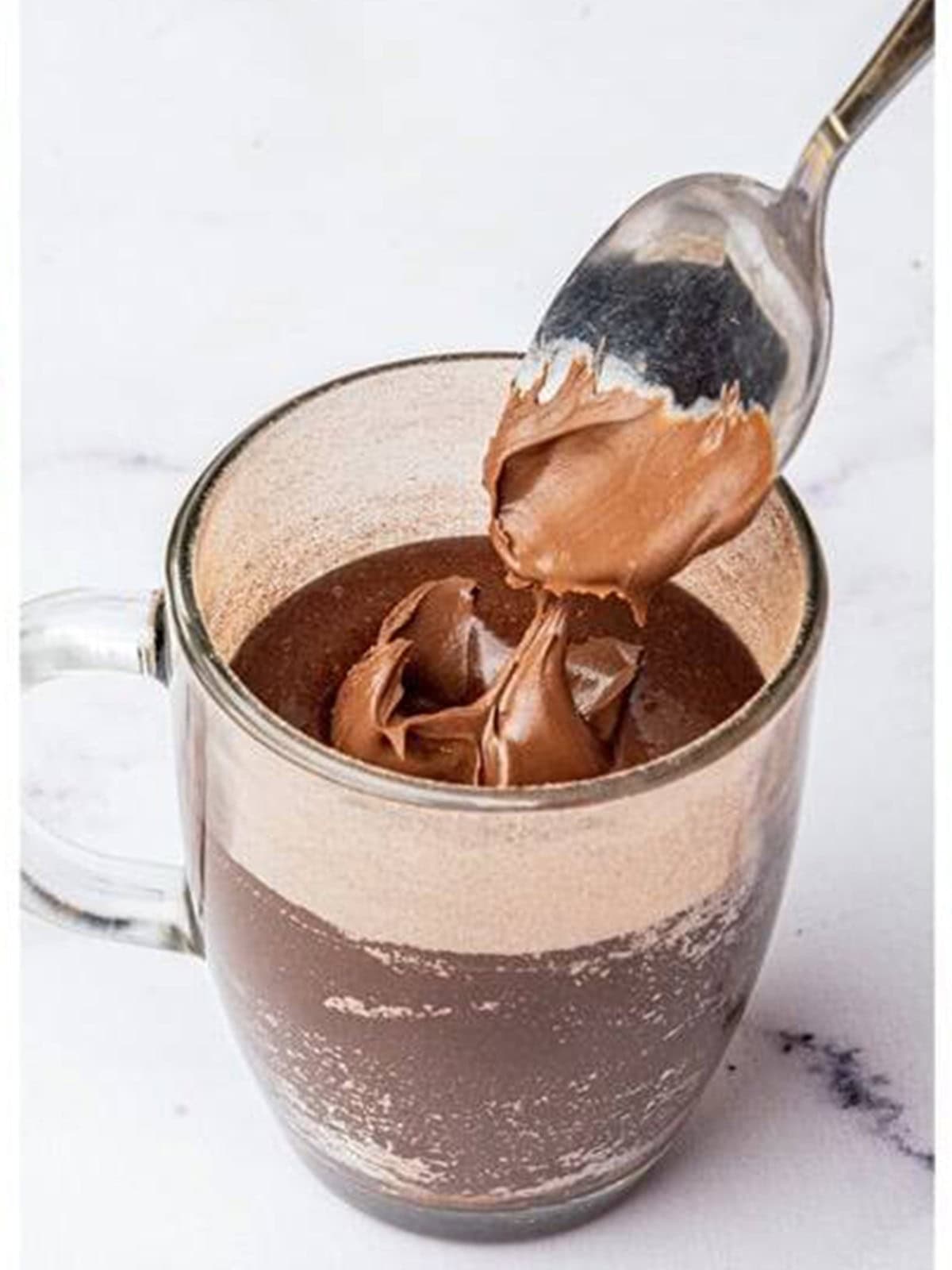 Adding a spoonful of Nutella into the center of the batter.