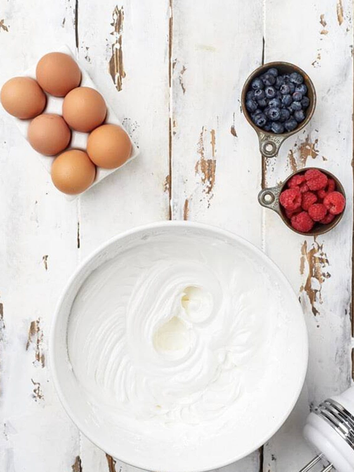 Spreading pastry cream over the cooled pavlova shell.