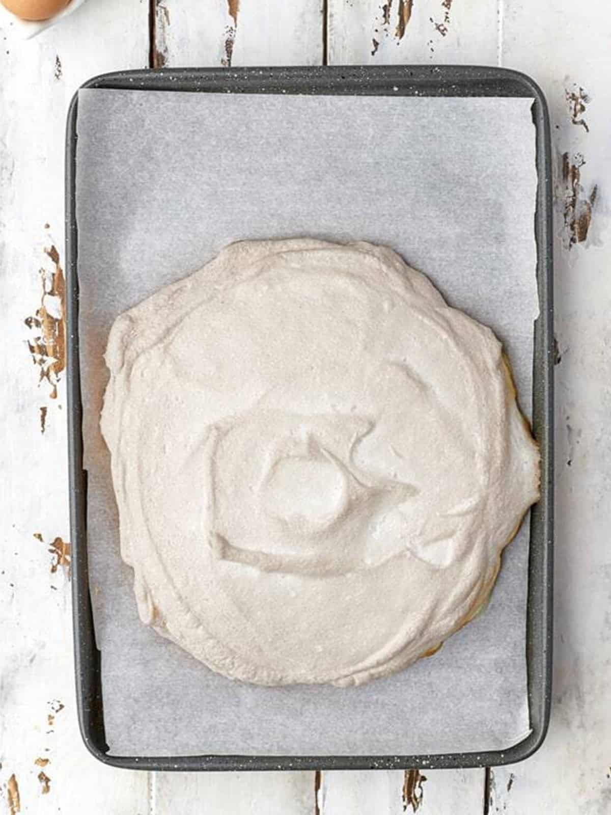 Baked crisp pavlova meringue shell cooling on the tray.