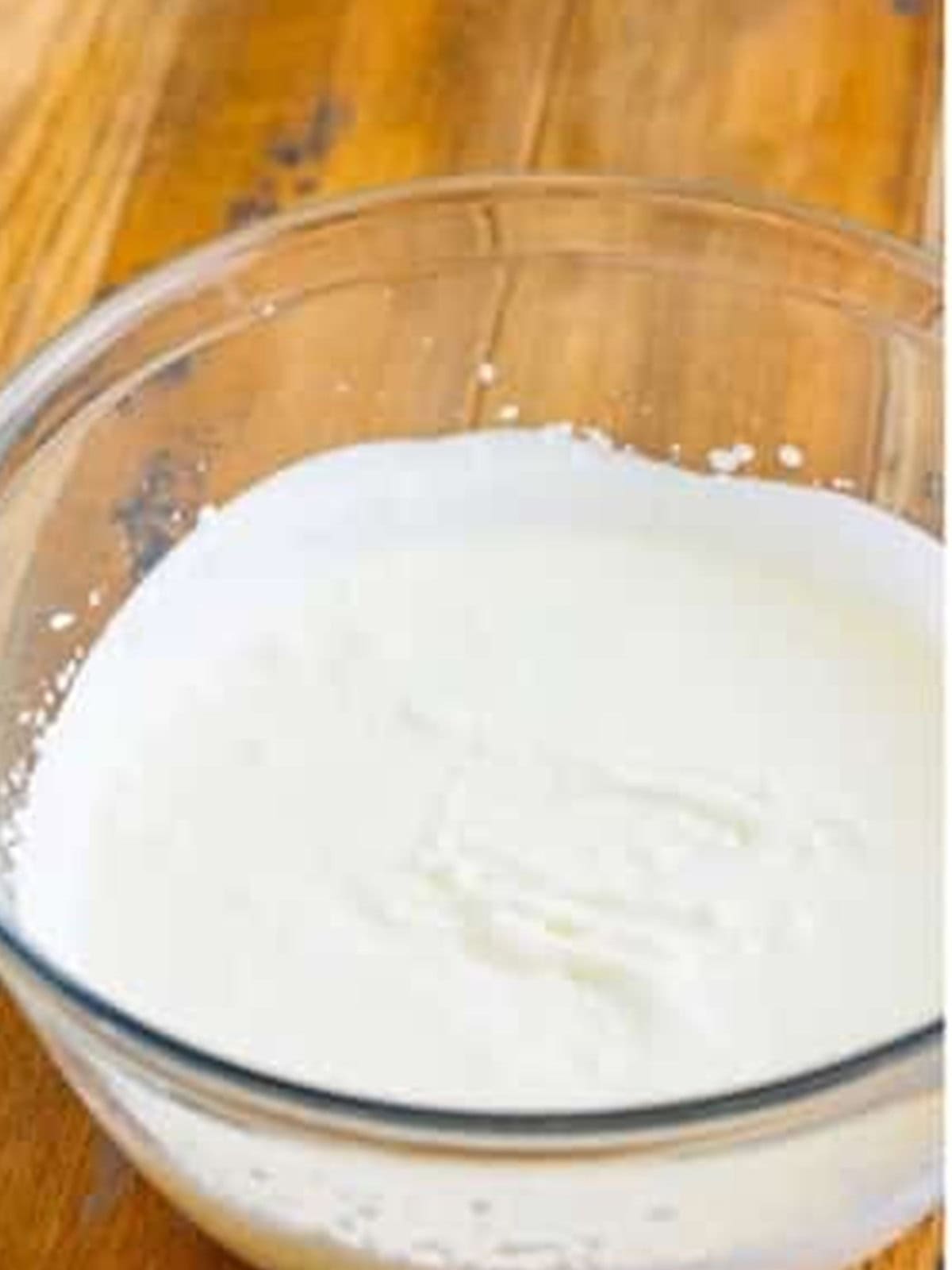 Heavy cream whipped to soft peaks in a glass bowl.