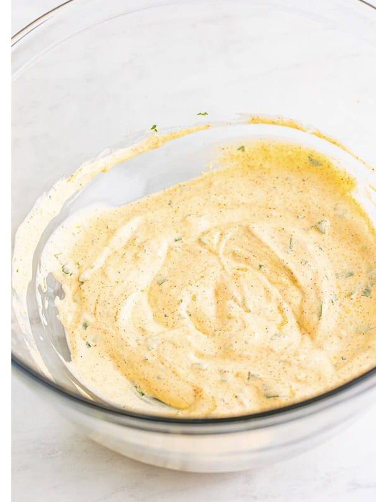 Creamy chicken salad dressing whisked together until smooth in a bowl.