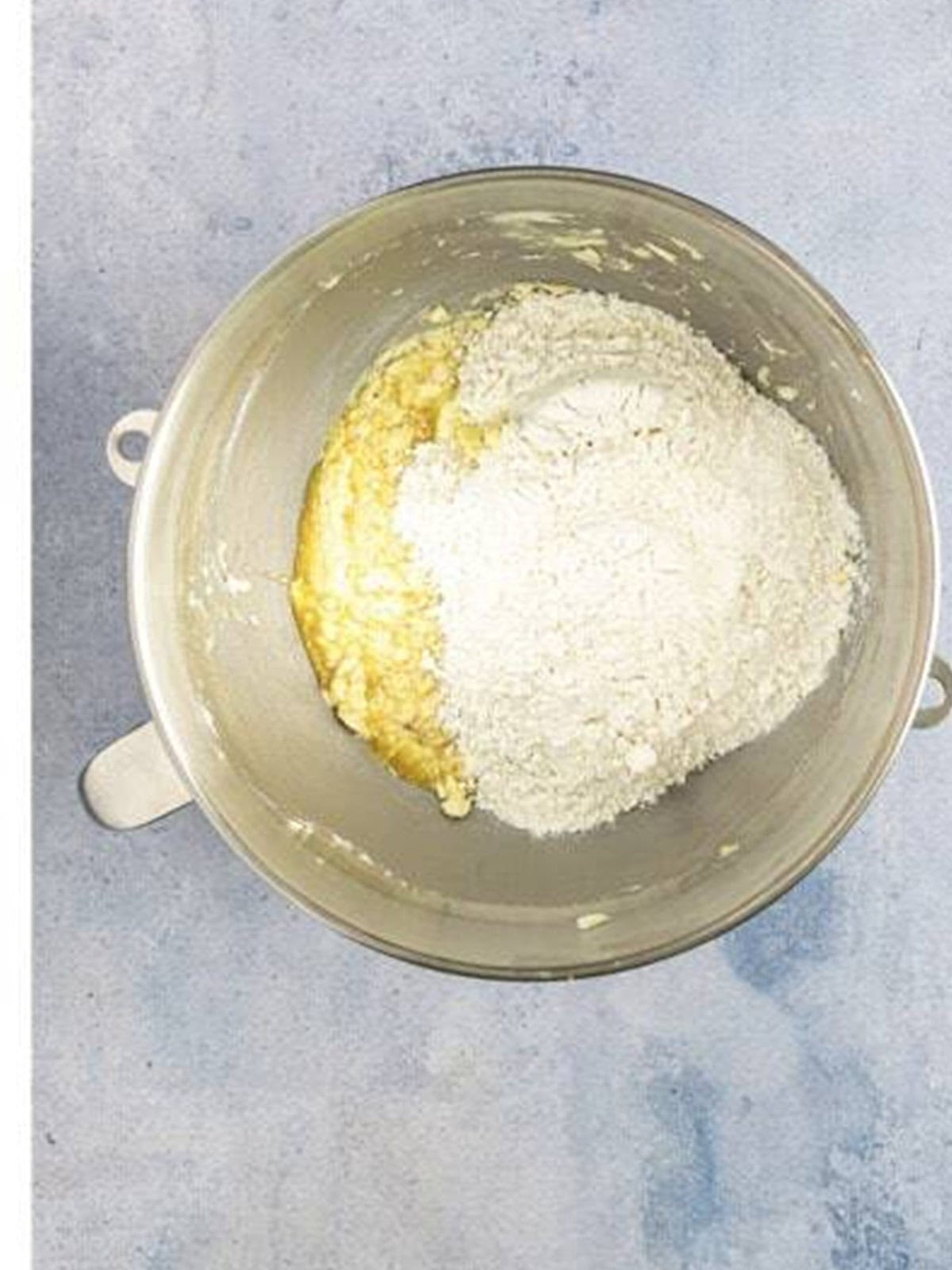 Adding flour to the tea cake dough.