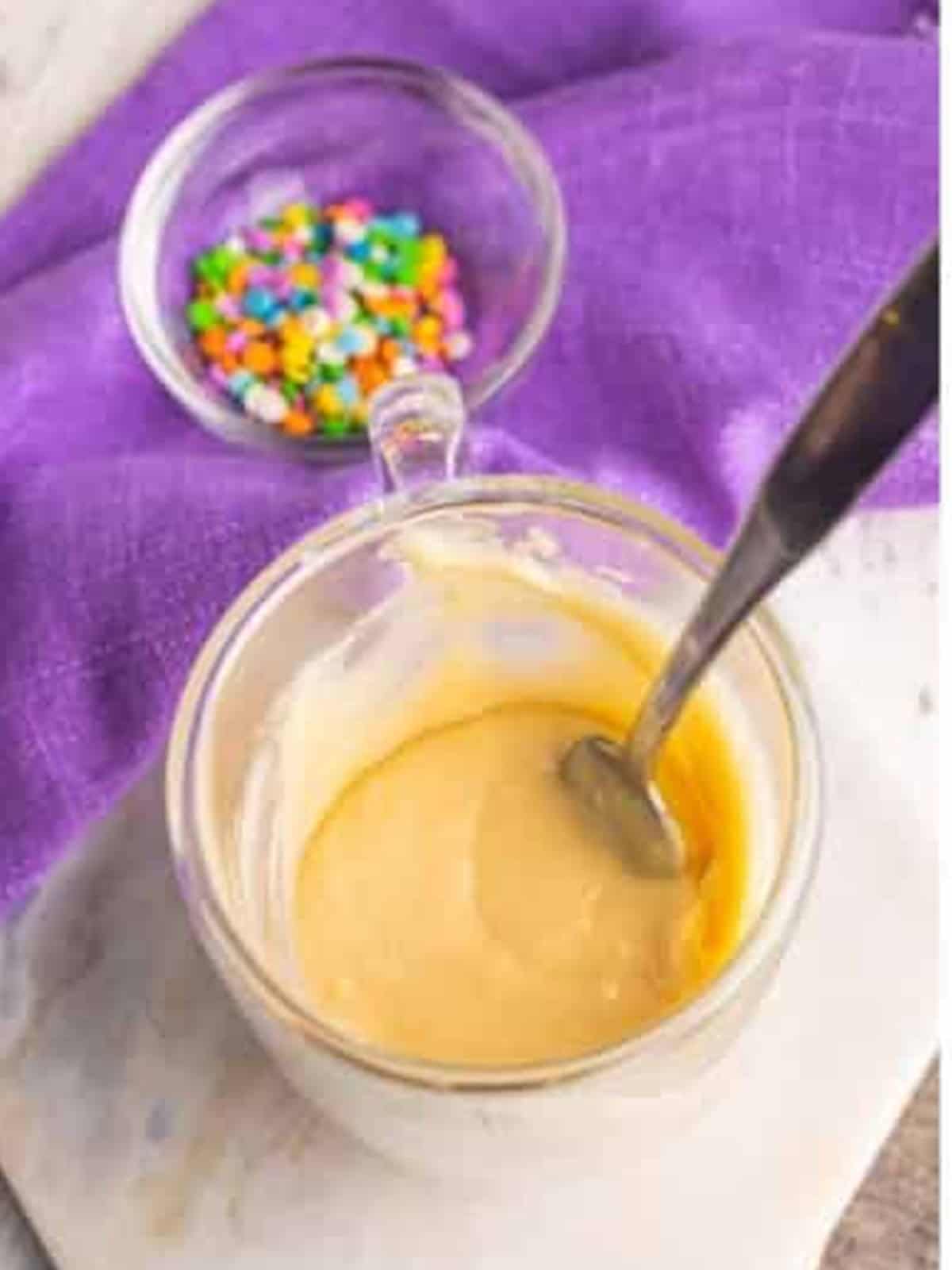 Stirring the vanilla mug cake batter until smooth with a spoon.