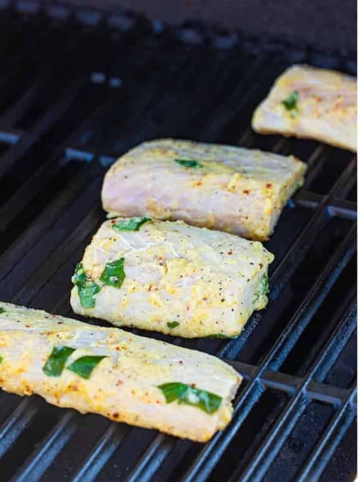 Marinated mahi filets cooking on a hot grill.