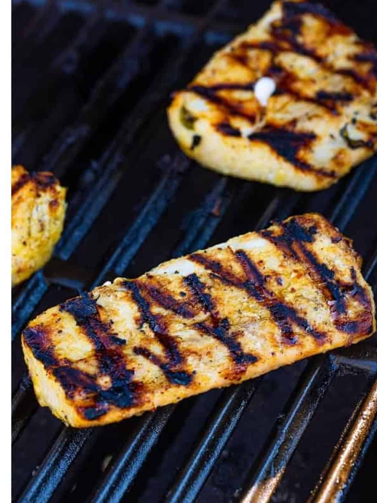 Grilled mahi mahi with golden grill marks on the grates.