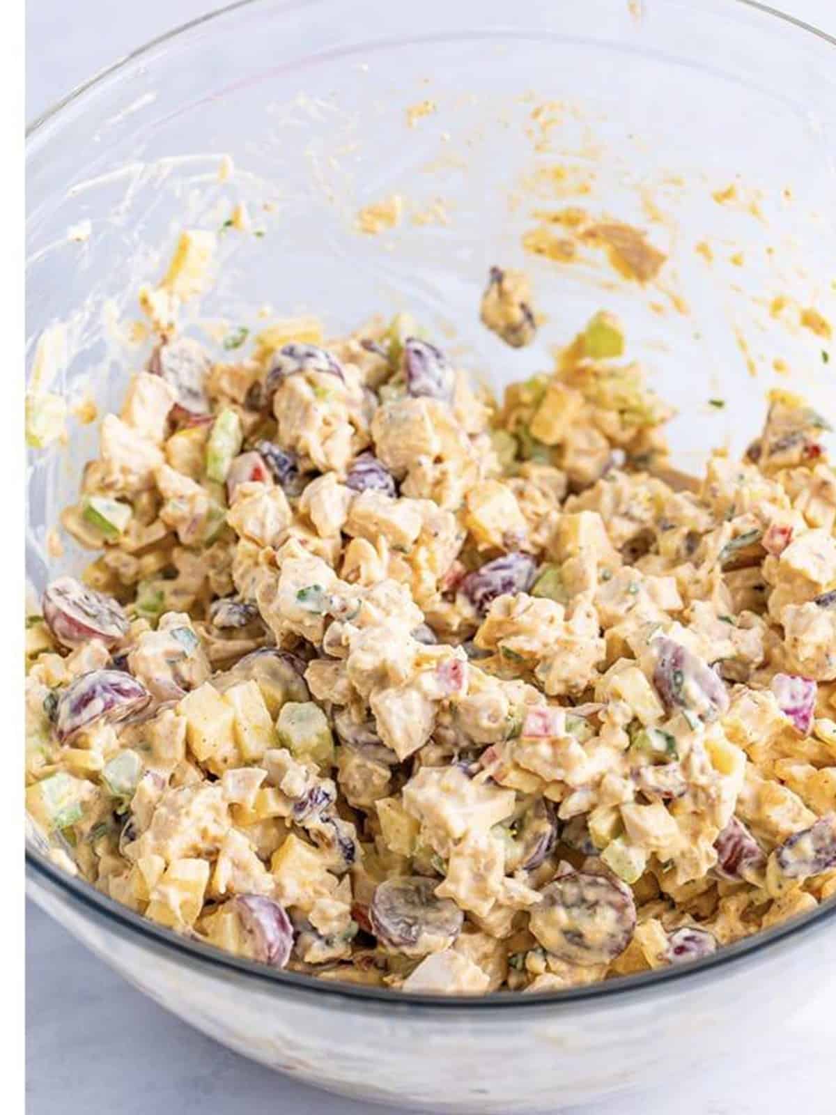 Chicken salad stirred together until evenly coated and ready to serve.