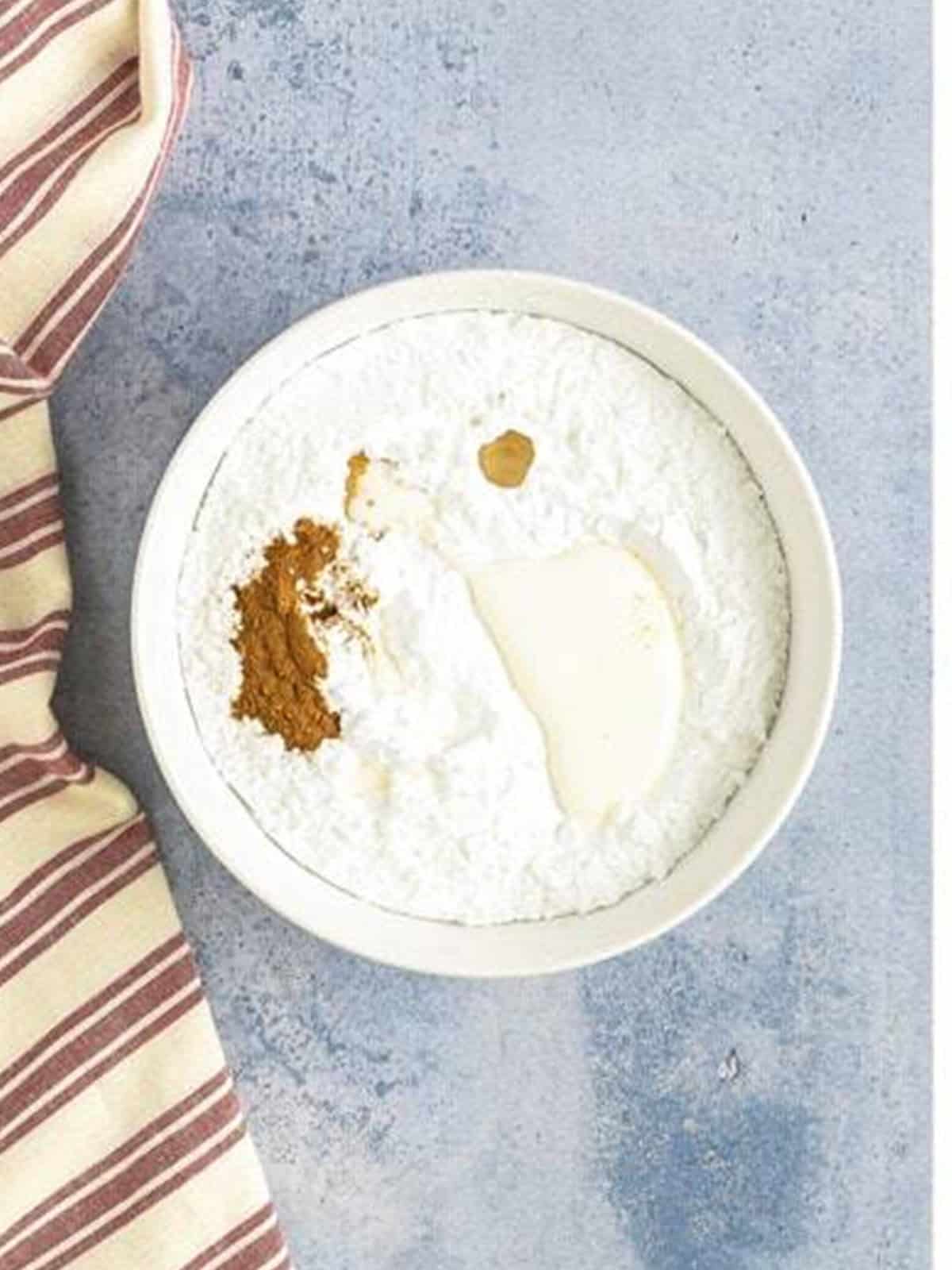 Powdered sugar, cinnamon, and milk in a bowl for the glaze.