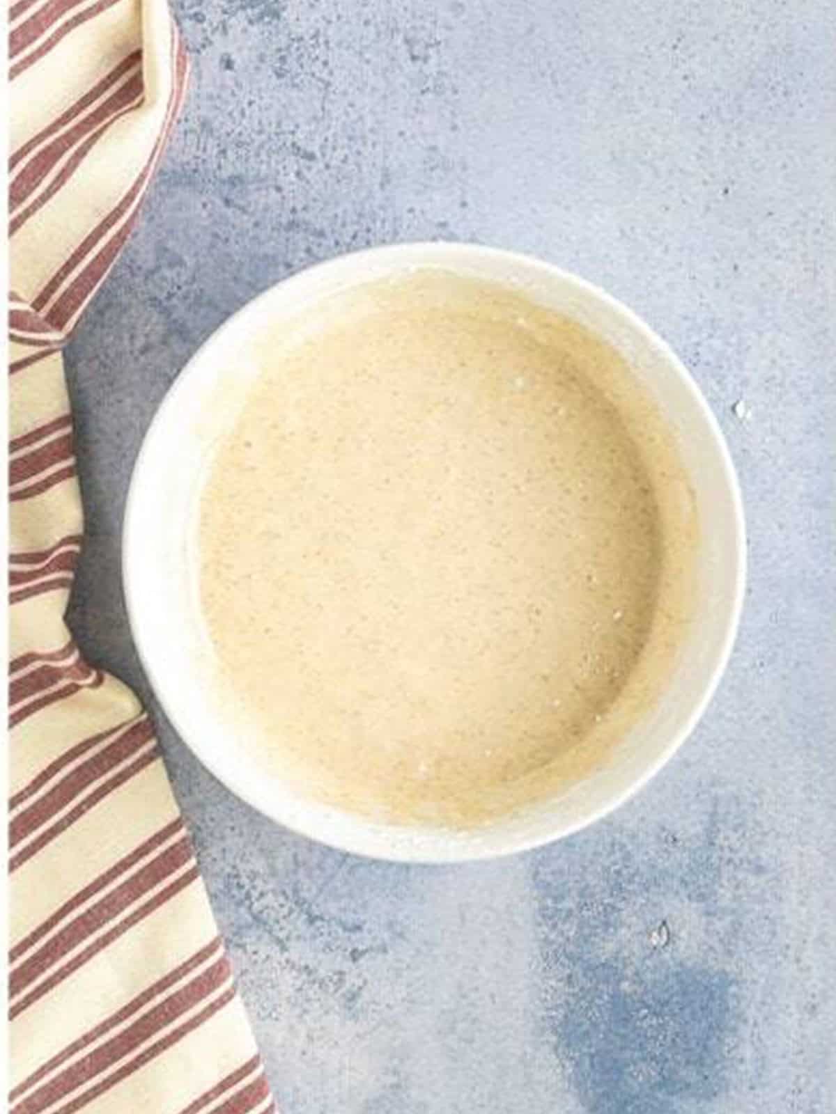The whisked cinnamon glaze in a bowl.