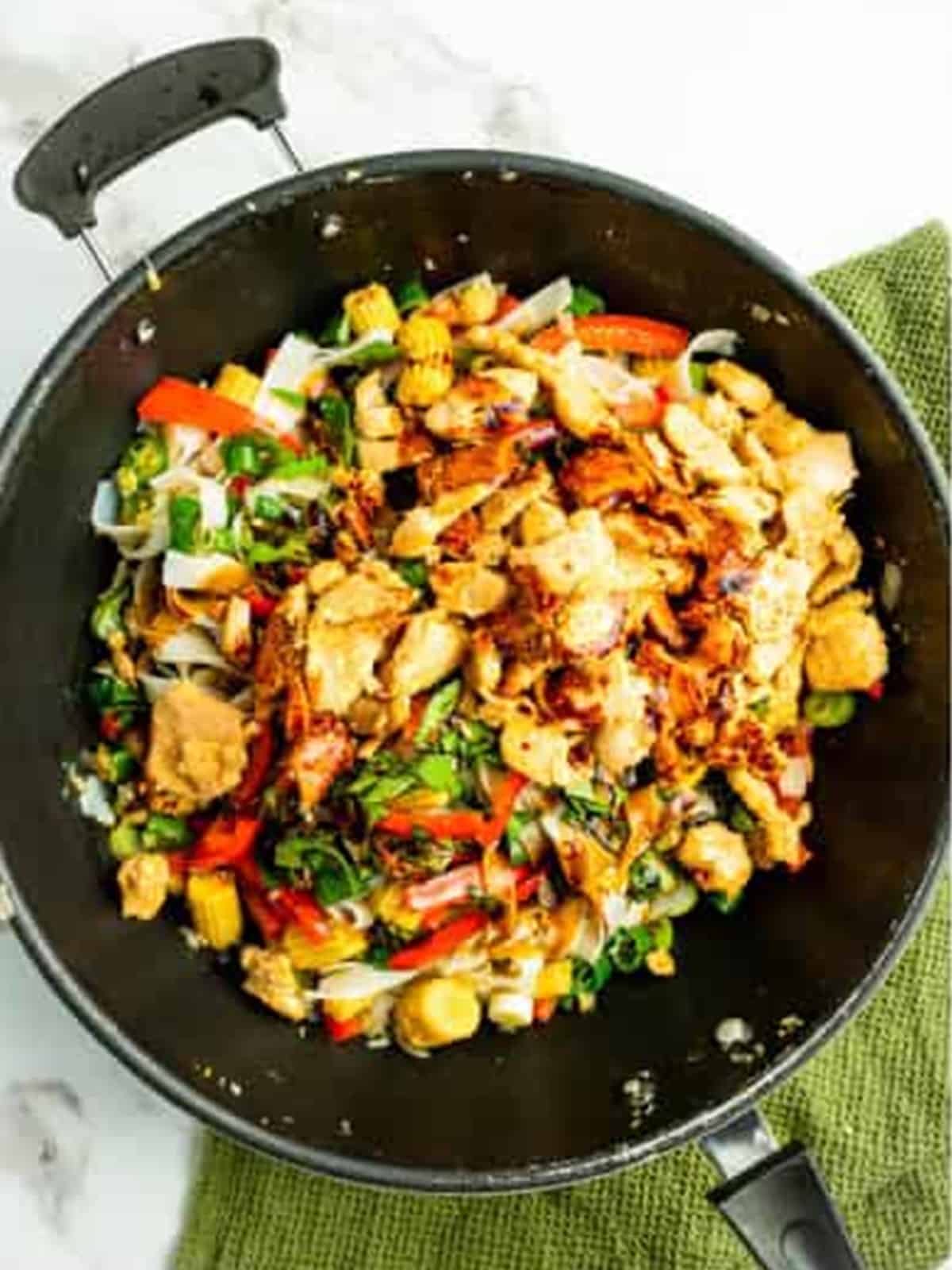 Drunken noodles cooking until everything is heated through and glossy.