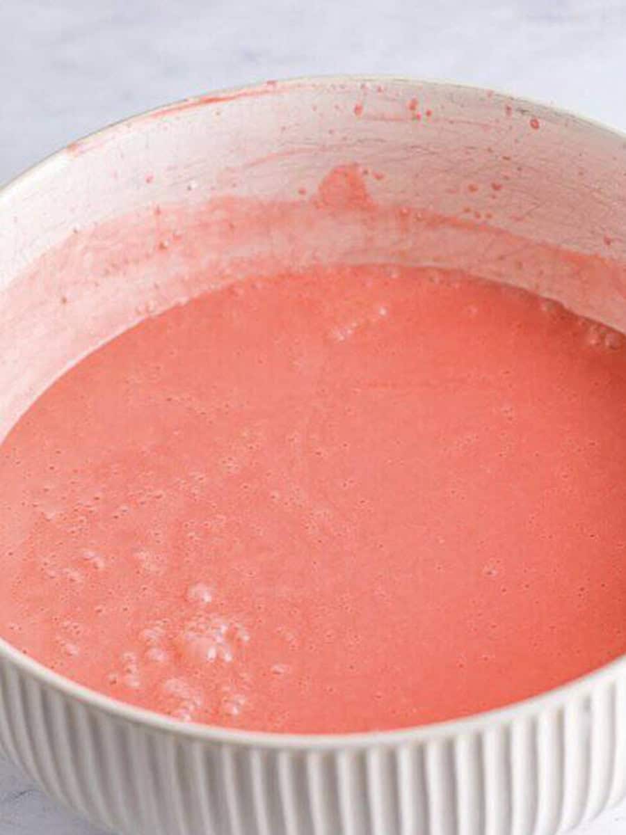 Smooth pink strawberry banana jello pie filling in a bowl.