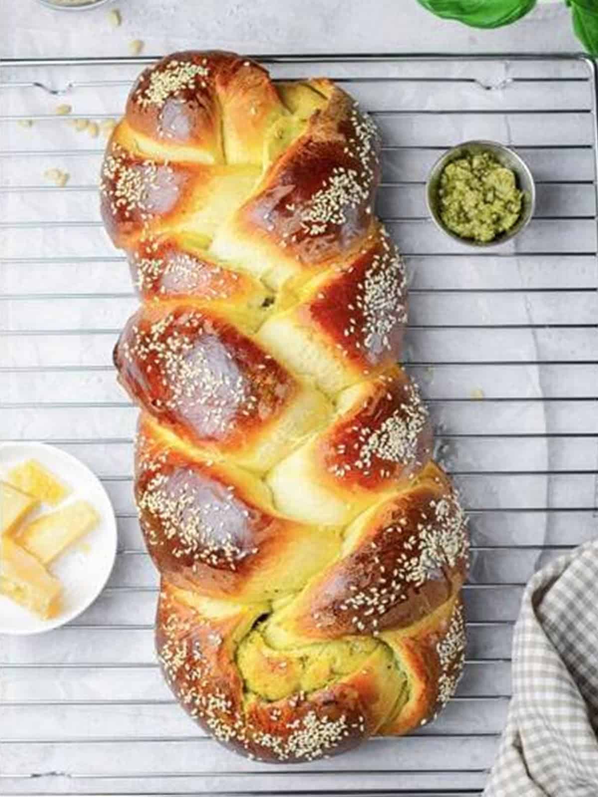 Golden brown baked challah bread loaf cooling on a wire rack.