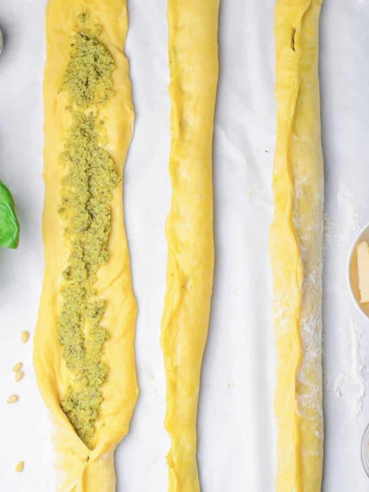Pesto filled challah bread dough ropes sealed and ready to braid.