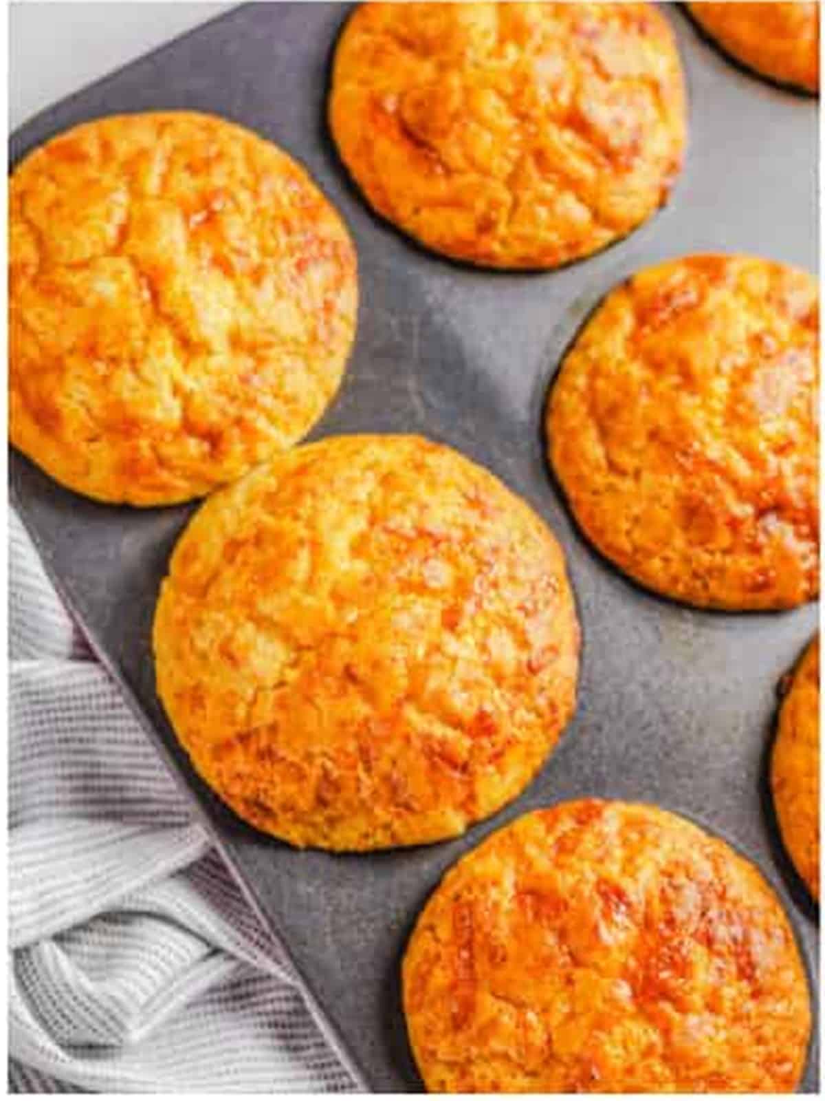 Golden baked cheese muffins fresh out of the oven in the tin.