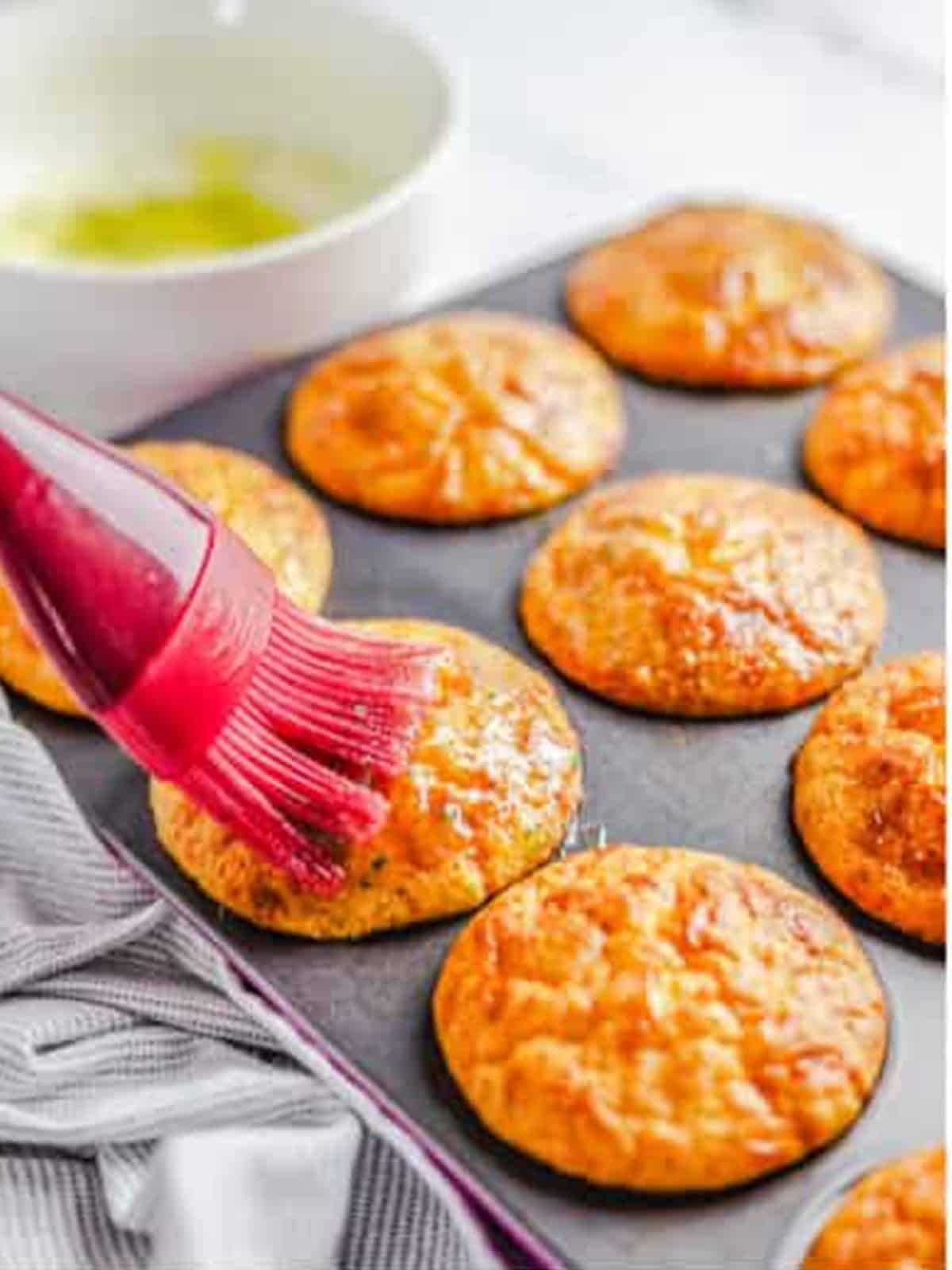 Garlic butter brushed over the hot cheese muffins with a pastry brush.